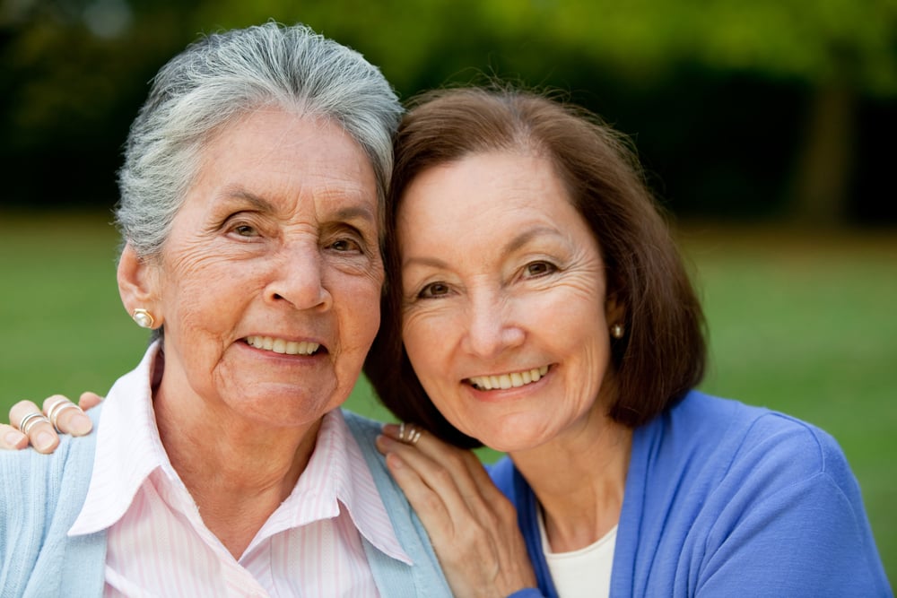 Portrait of an elder mother and daughter smiling outdoors